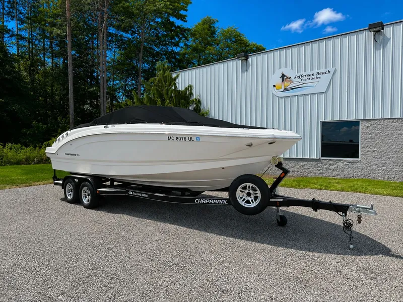 Slide: The Image of A white 2020 Chaparral 24 SSI boat on a trailer in front of a building. - 4