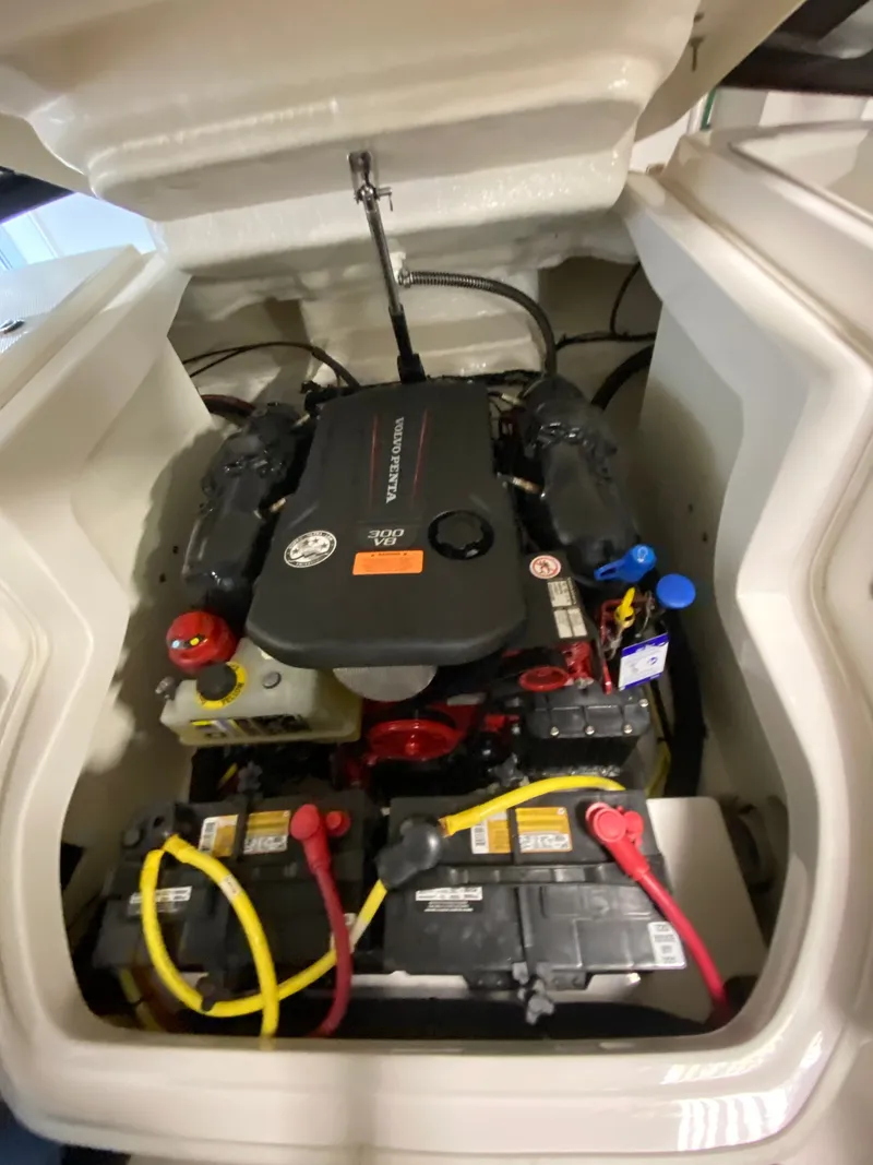 Slide: The Image of The engine compartment of a 2020 Chaparral 24 SSI shows a well-organized engine with batteries. - 31