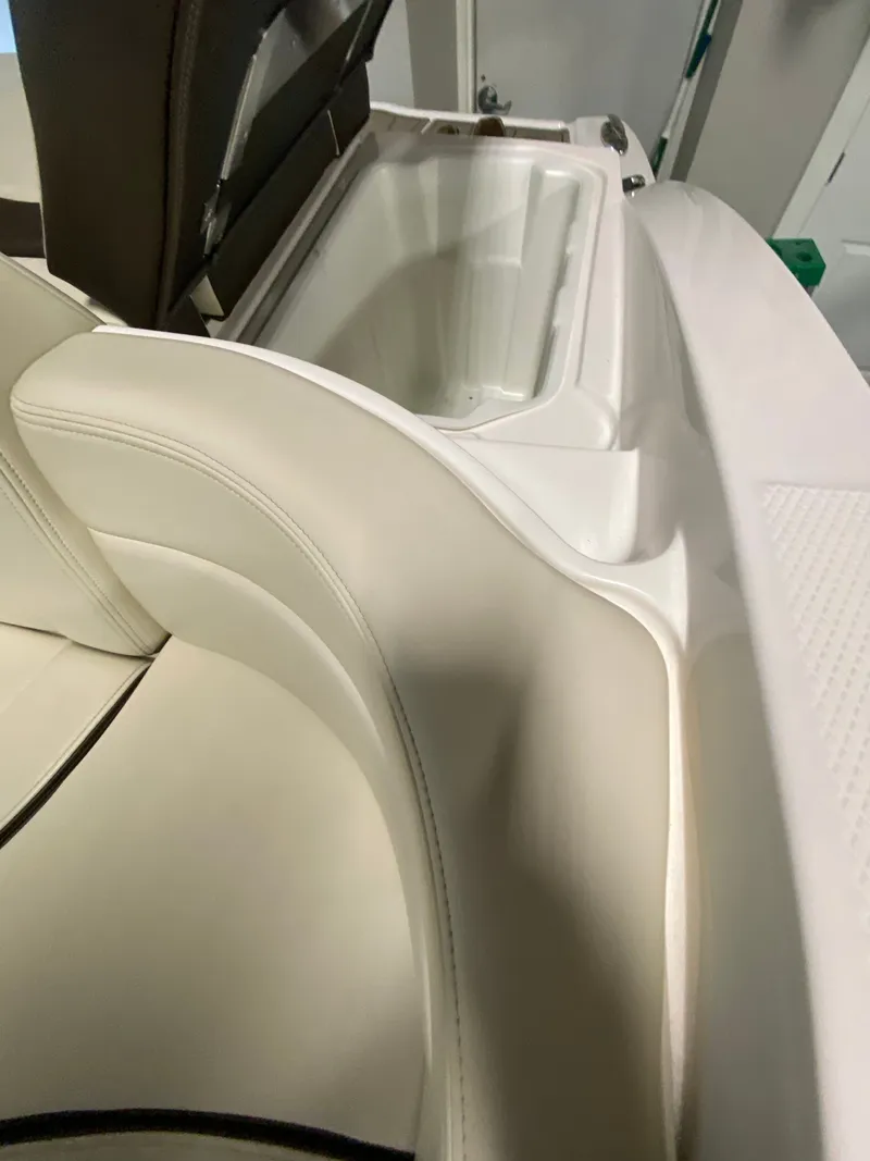 Slide: The Image of Interior view of a 2020 Chaparral 24 SSI with beige upholstery and storage compartment. - 23