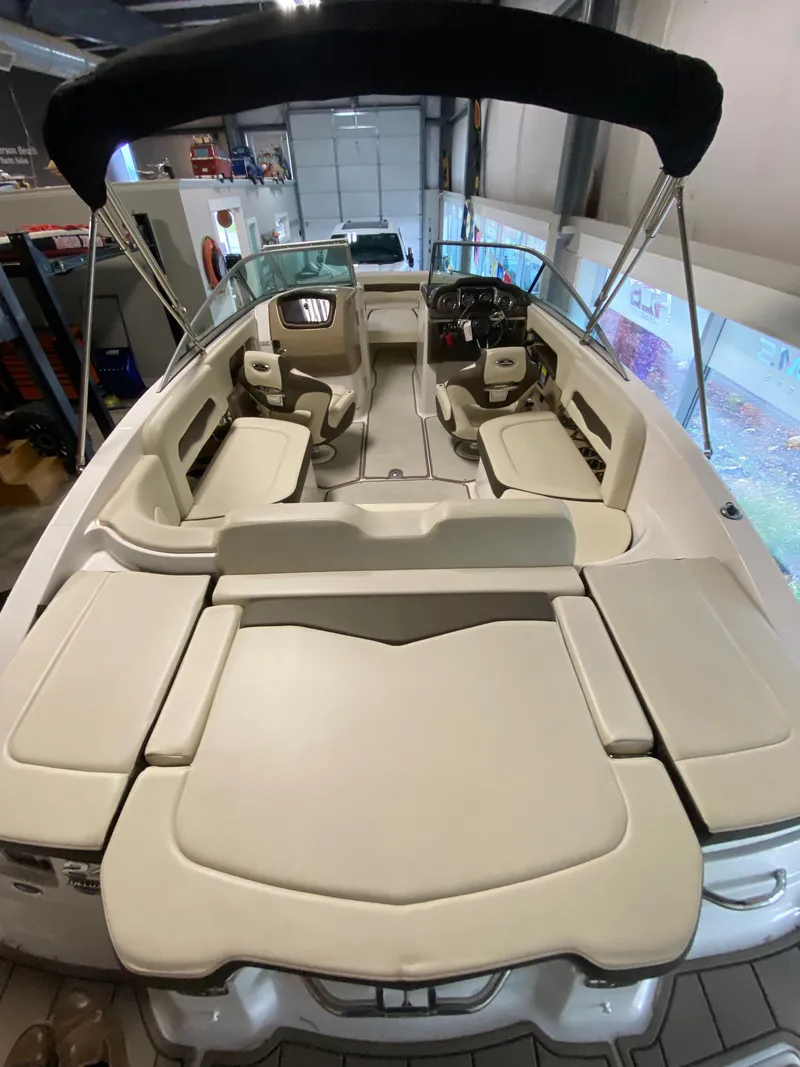 Slide: The Image of Interior view of a Chaparral 24 SSI boat with beige upholstery and a black bimini top. - 16
