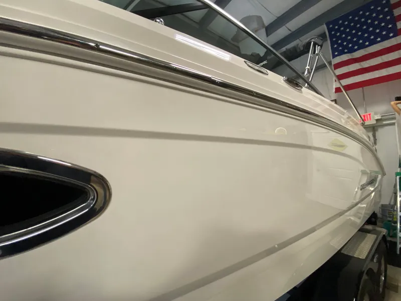 Slide: The Image of Side view of a white Chaparral 24 SSI boat in a warehouse with an American flag. - 13