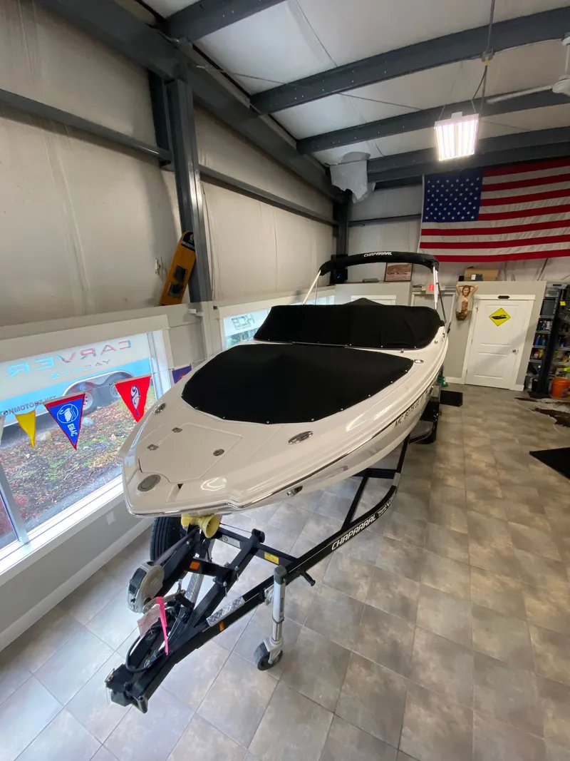 Slide: The Image of 2020 Chaparral 24 SSI on a trailer indoors, with an American flag in the background. - 10