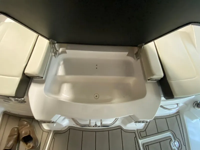 Slide: The Image of The image shows the interior of a 2020 Chaparral 24 SSI boat with built-in storage. - 24