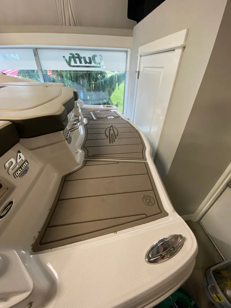 Slide: The Image of The image shows the stern of a 2020 Chaparral 24 SSI boat in an indoor setting. - 21