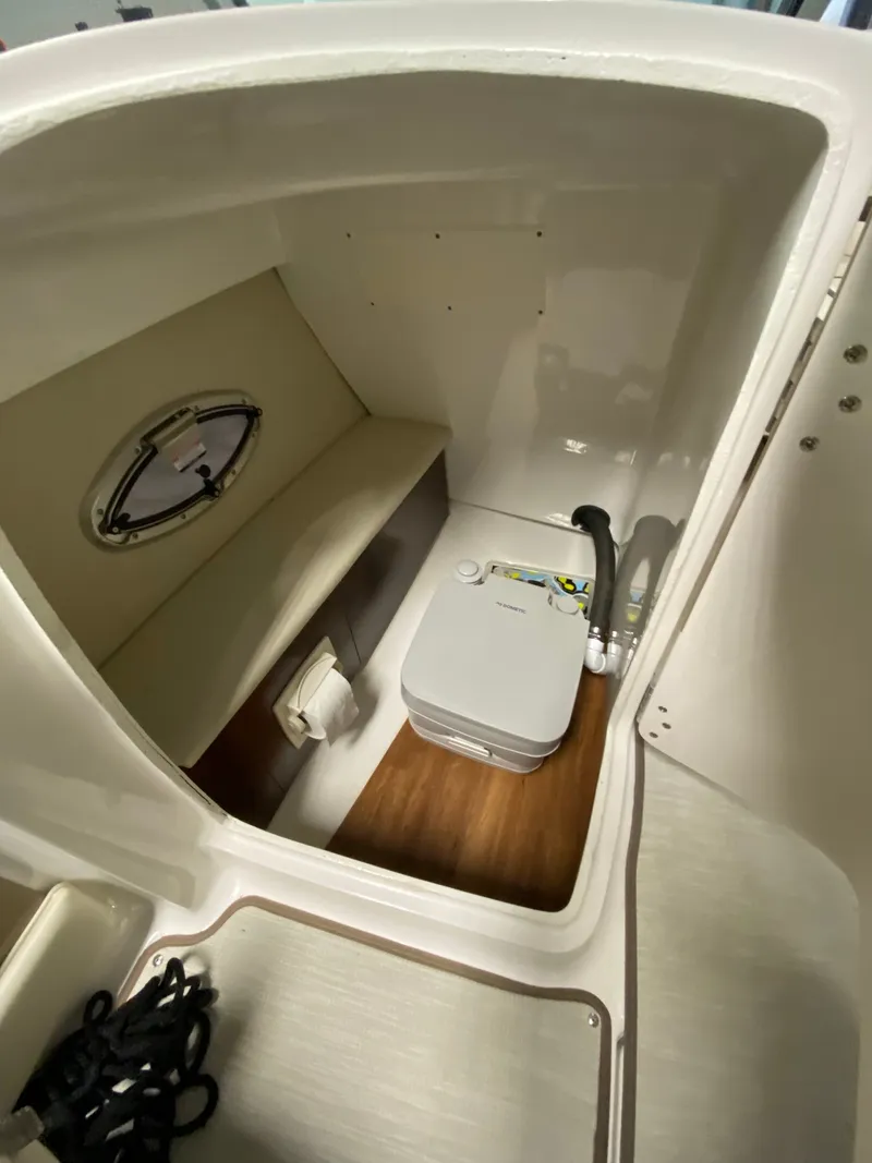 Slide: The Image of Interior of a 2020 Chaparral 24 SSI with a bench seat and portable toilet. - 7