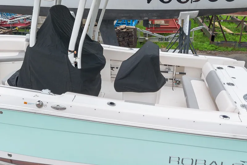 Slide: The Image of 2017 Robalo R242 Center Console boat with covered seating and mint green hull. - 40