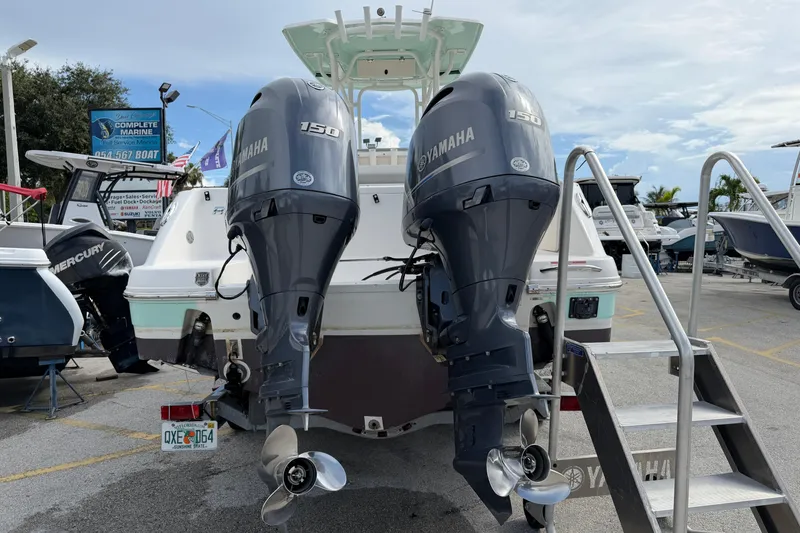 Slide: The Image of 2017 Robalo R242 Center Console with twin Yamaha 150 engines at a marina. - 11
