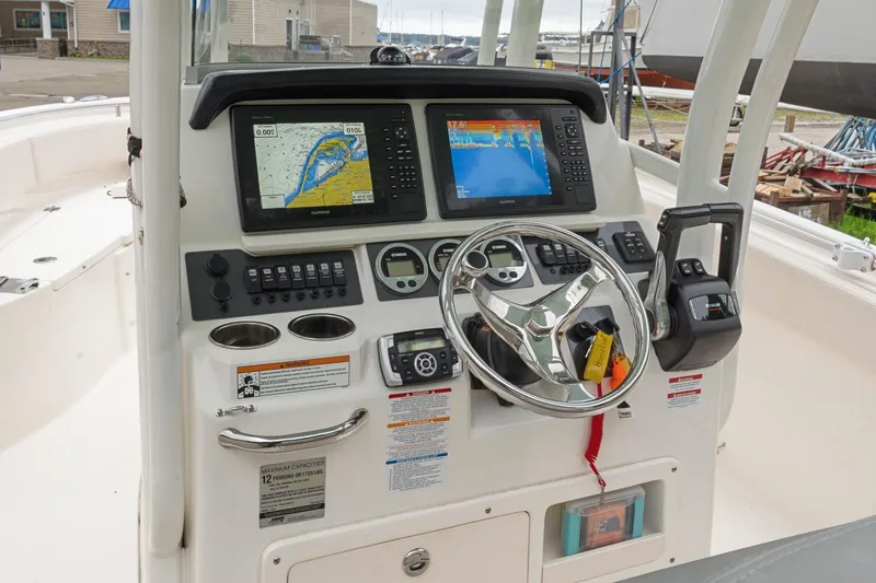 Slide: The Image of 2017 Robalo R242 Center Console boat dashboard with navigation screens and steering wheel. - 21