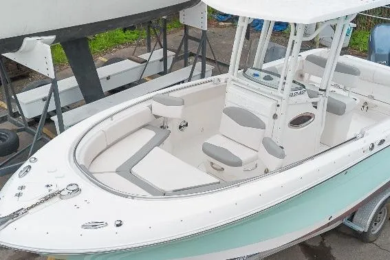 Slide: The Image of 2017 Robalo R242 Center Console boat with white and gray seating, docked on trailer. - 47