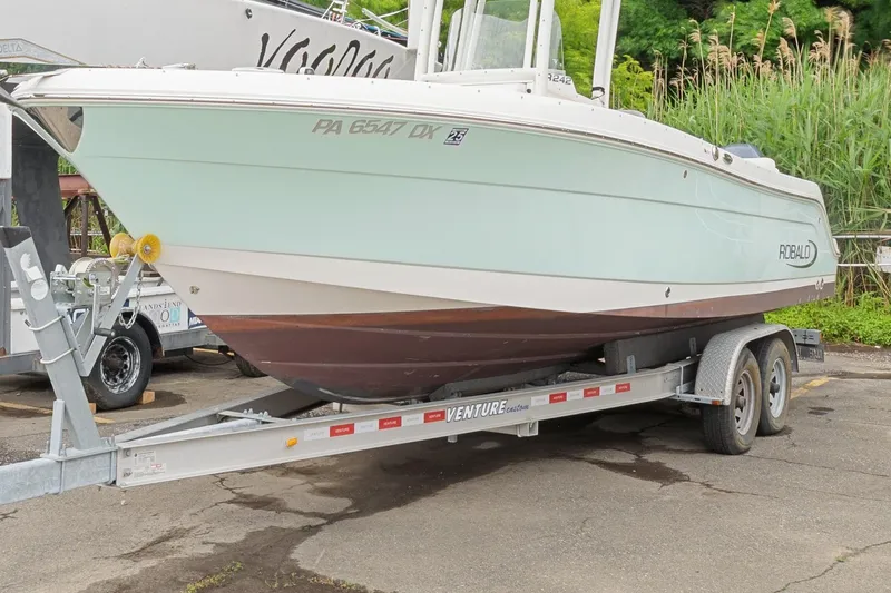Slide: The Image of 2017 Robalo R242 Center Console boat on trailer, parked outdoors. - 10