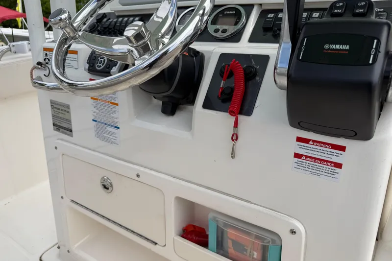 Slide: The Image of 2017 Robalo R242 Center Console boat dashboard with steering wheel and controls. - 65