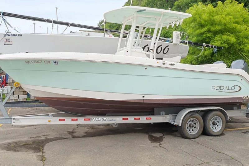 Slide: The Image of 2017 Robalo R242 Center Console boat on trailer, parked outdoors. - 6