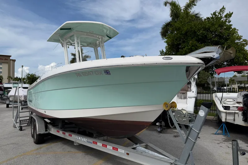 The Image of 2017 Robalo R242 Center Console boat on trailer, parked outdoors under a clear sky. - 1