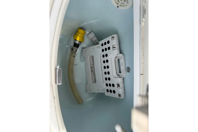 Slide: The Image of Interior view of a 2017 Robalo R242 Center Console boat compartment with hose and fittings. - 69