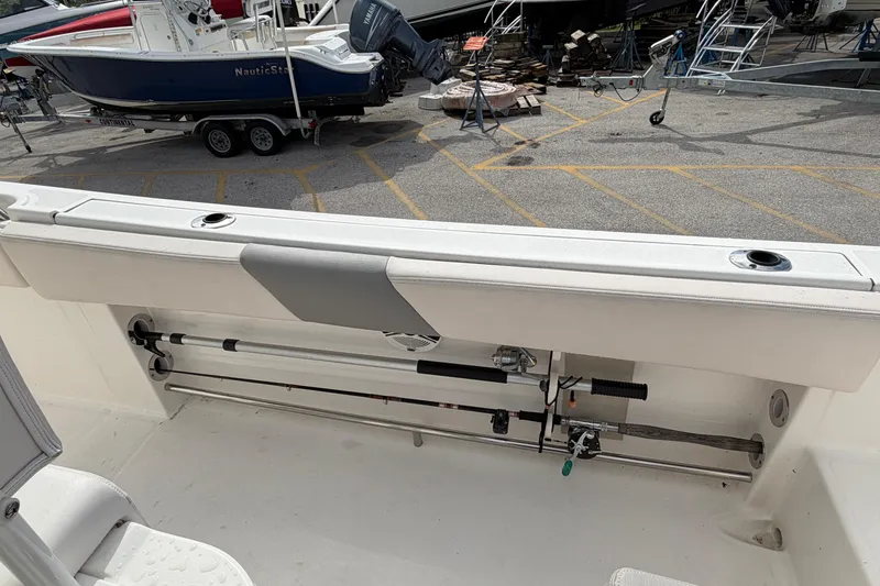 Slide: The Image of 2017 Robalo R242 Center Console boat with fishing rod storage in a marina setting. - 36