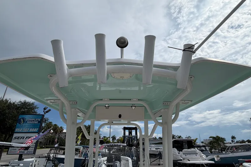 Slide: The Image of 2017 Robalo R242 Center Console boat with rod holders and canopy, docked at a marina. - 22