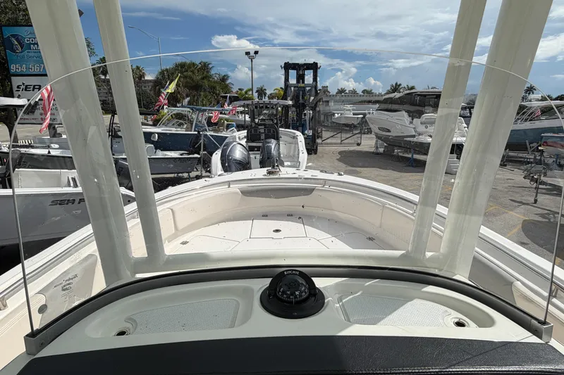 Slide: The Image of 2017 Robalo R242 Center Console boat at a marina, surrounded by other vessels. - 58