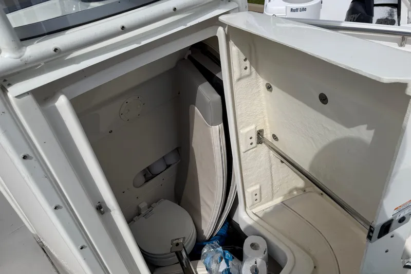 Slide: The Image of 2017 Robalo R242 Center Console boat interior with storage and toilet area. - 34