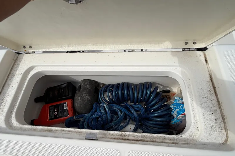 Slide: The Image of Open storage compartment on 2017 Robalo R242 Center Console boat with various items inside. - 50