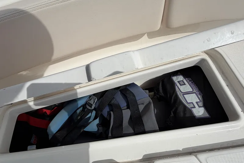 Slide: The Image of Storage compartment on a 2017 Robalo R242 Center Console boat with bags and gear. - 55