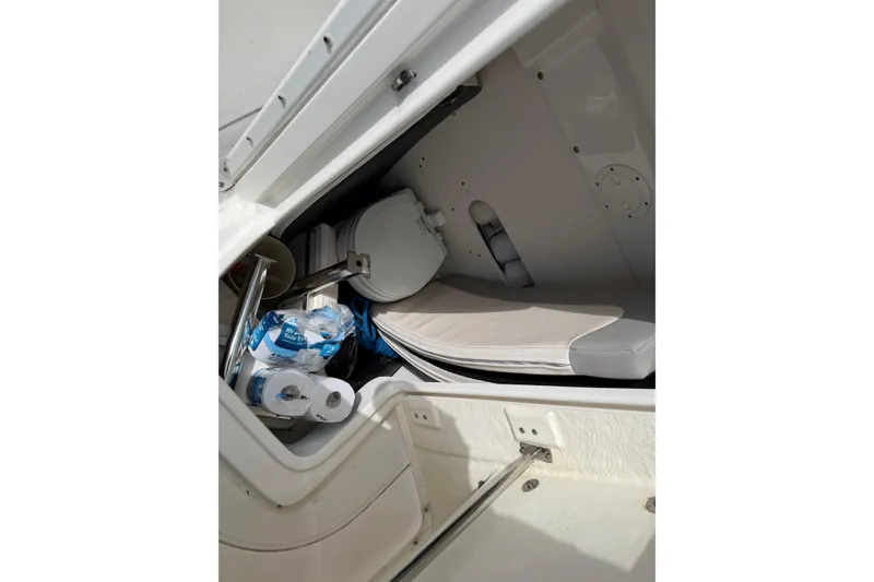 Slide: The Image of 2017 Robalo R242 Center Console boat storage with toilet paper and cushions. - 62