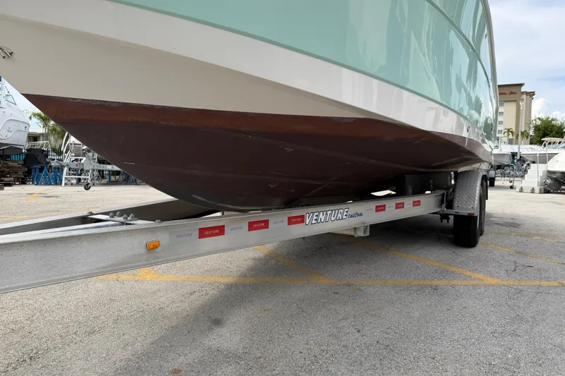 Slide: The Image of 2017 Robalo R242 Center Console boat on a Venture trailer in a parking lot. - 48