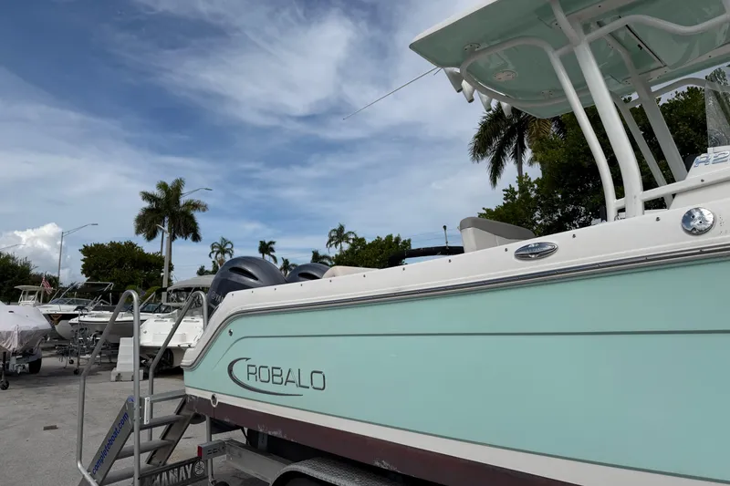 Slide: The Image of 2017 Robalo R242 Center Console boat on trailer, palm trees in background. - 5