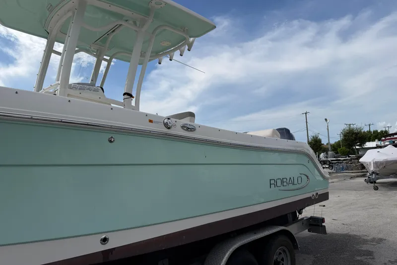 Slide: The Image of 2017 Robalo R242 Center Console boat on trailer under a clear blue sky. - 4