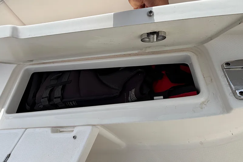 Slide: The Image of Storage compartment on a 2017 Robalo R242 Center Console boat with life jackets inside. - 52
