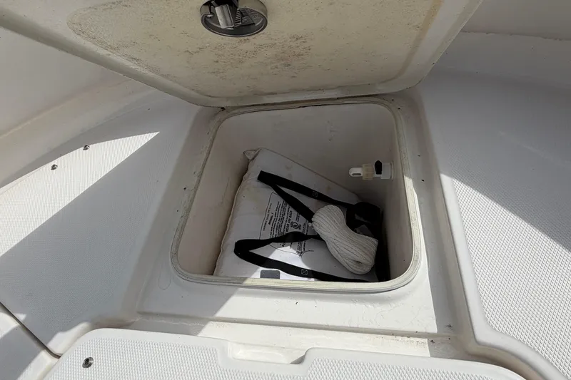 Slide: The Image of Storage compartment on a 2017 Robalo R242 Center Console boat, containing safety equipment. - 53