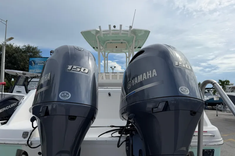 Slide: The Image of 2017 Robalo R242 Center Console with twin Yamaha 150 engines at a marina. - 12