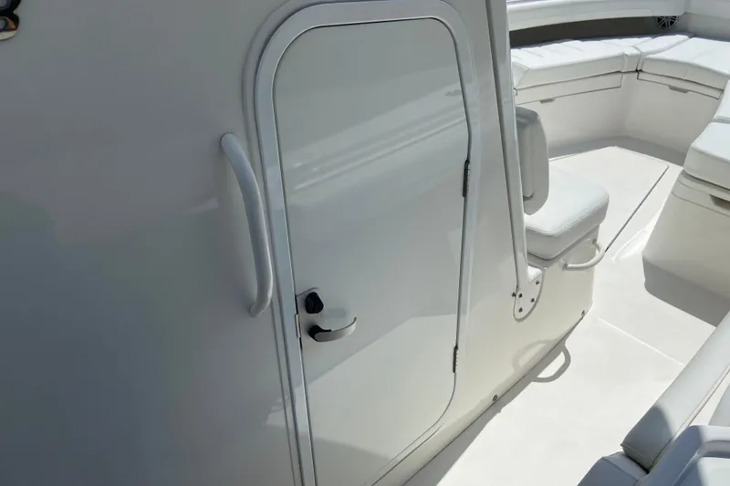 Slide: The Image of 2021 Regulator 28 boat interior with white seating and cabin door. - 46