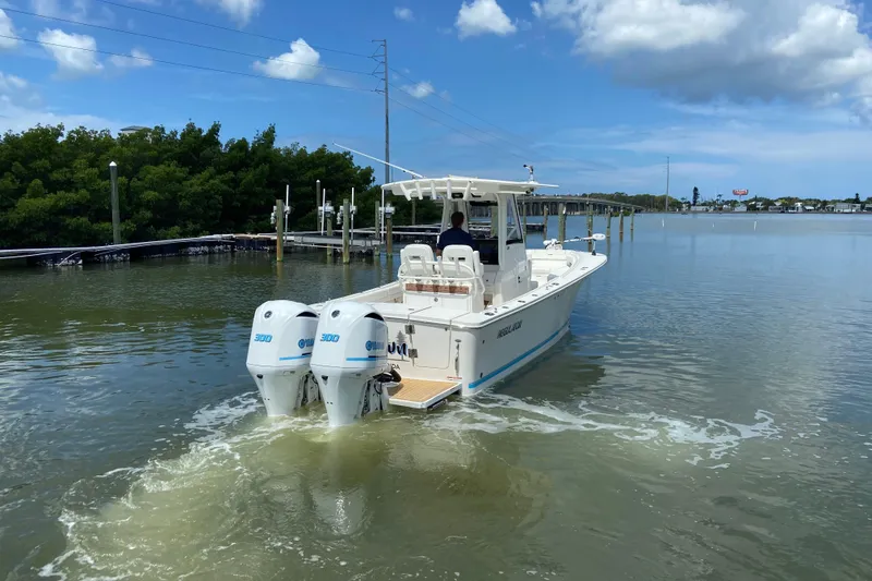 Slide: The Image of 2021 Regulator 28 boat with twin Yamaha engines cruising in calm waters. - 11