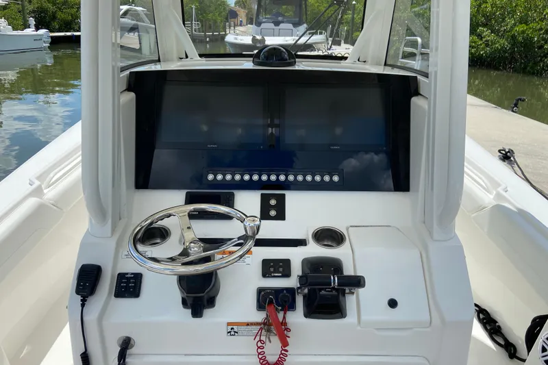 Slide: The Image of 2021 Regulator 28 boat helm with steering wheel and navigation screens. - 27