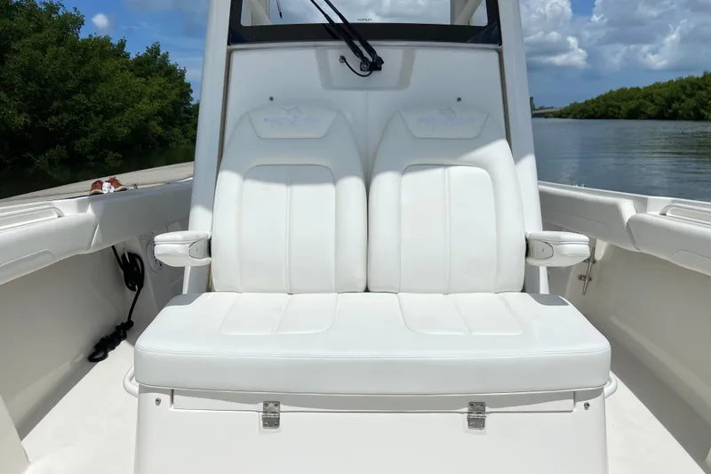Slide: The Image of 2021 Regulator 28 boat with white seating, docked on a sunny day. - 49