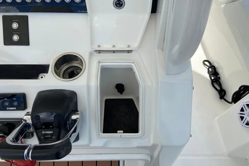 Slide: The Image of Control panel of a 2021 Regulator 28 boat featuring Yamaha throttle and storage compartment. - 33