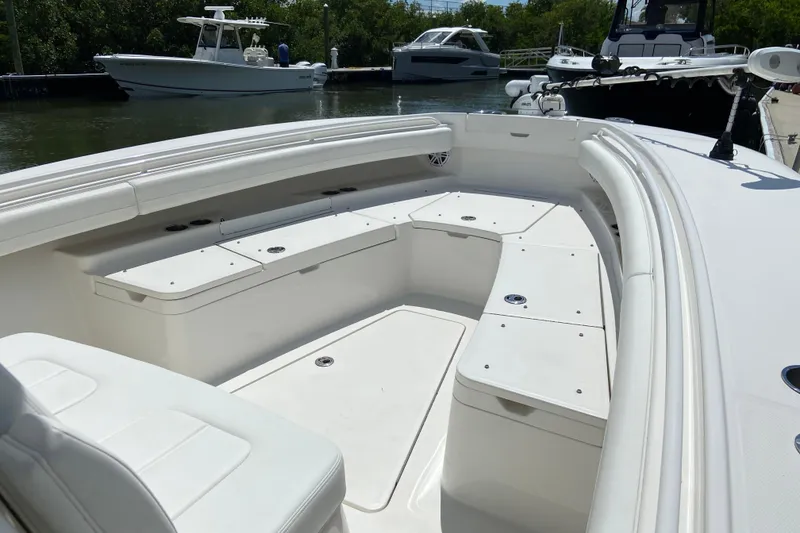 Slide: The Image of 2021 Regulator 28 boat interior with spacious seating and sleek design in a marina setting. - 34