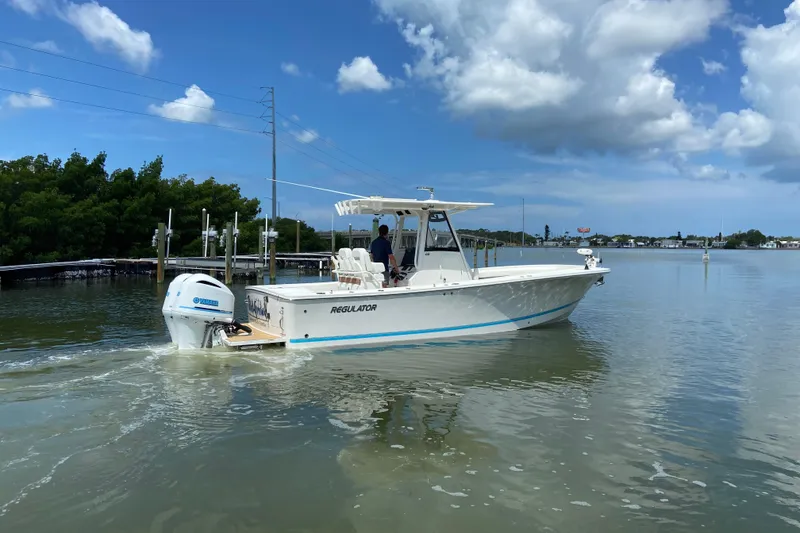 Slide: The Image of 2021 Regulator 28 boat cruising on calm waters under a clear blue sky. - 9
