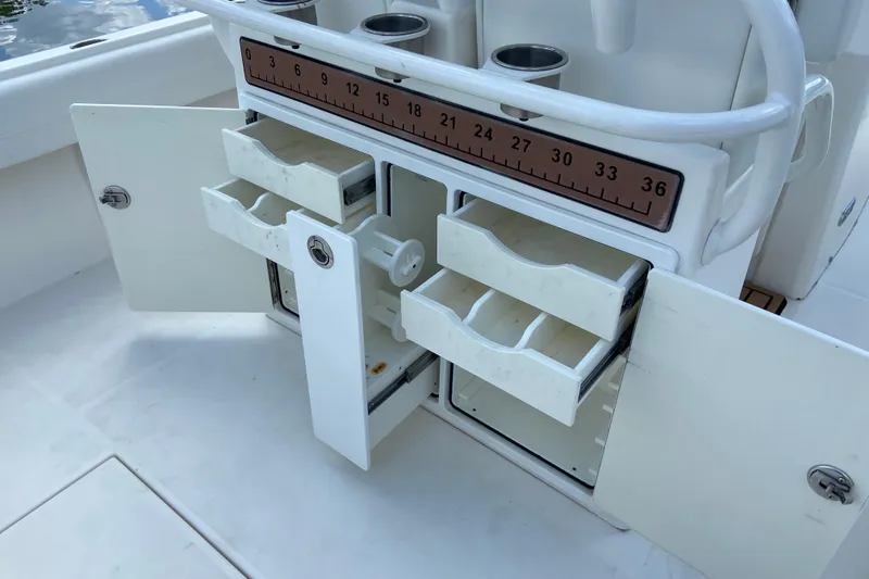 Slide: The Image of 2021 Regulator 28 boat storage compartments with open drawers and measuring ruler. - 22