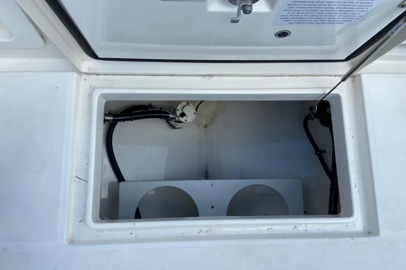 Slide: The Image of Open storage compartment on a 2021 Regulator 28 boat, showing interior details and wiring. - 20