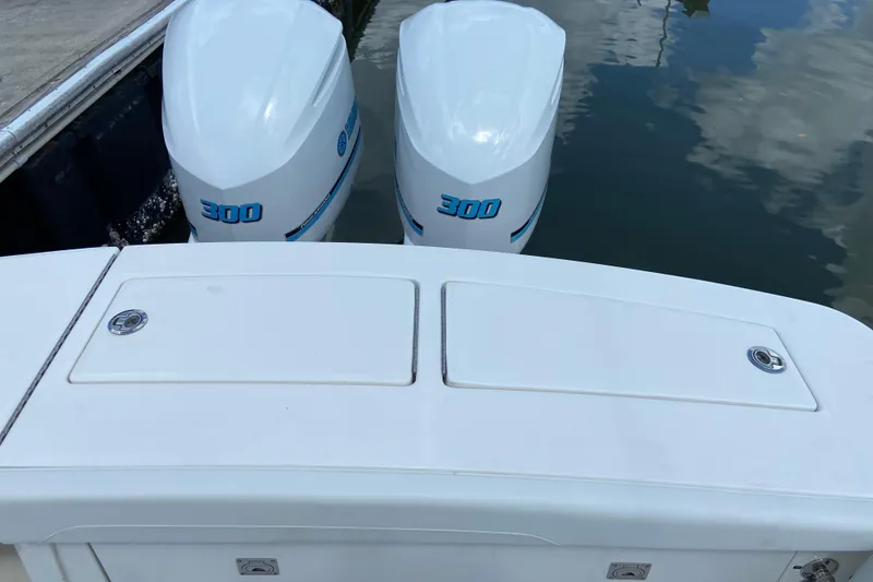 Slide: The Image of 2021 Regulator 28 boat with twin 300 horsepower engines docked on calm water. - 16