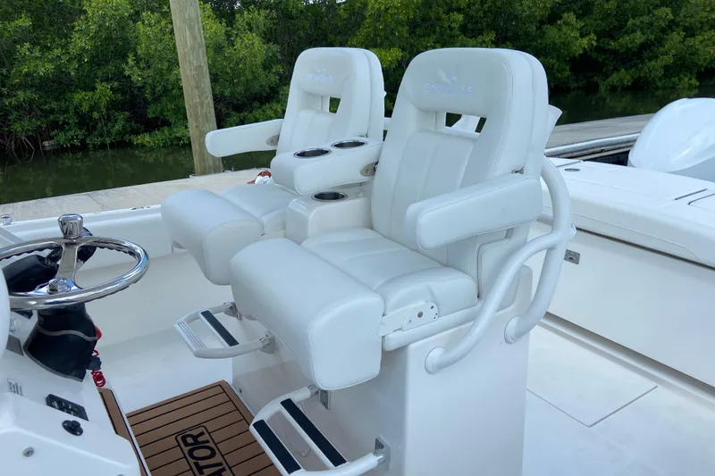 Slide: The Image of 2021 Regulator 28 boat with white cushioned helm seats and steering wheel. - 26