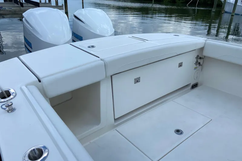 Slide: The Image of 2021 Regulator 28 boat interior with storage compartments and twin outboard engines. - 14
