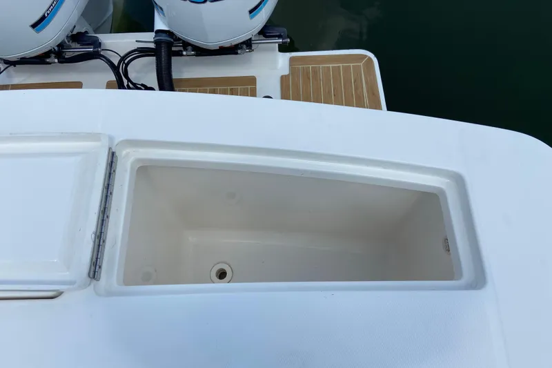 Slide: The Image of Open storage compartment on 2021 Regulator 28 boat, near twin outboard engines. - 18