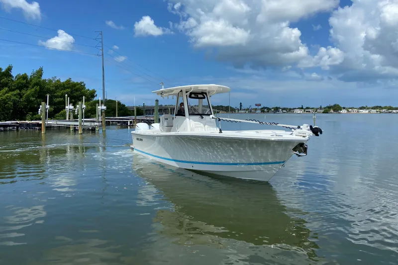 Slide: The Image of 2021 Regulator 28 boat on calm water under a partly cloudy sky. - 5