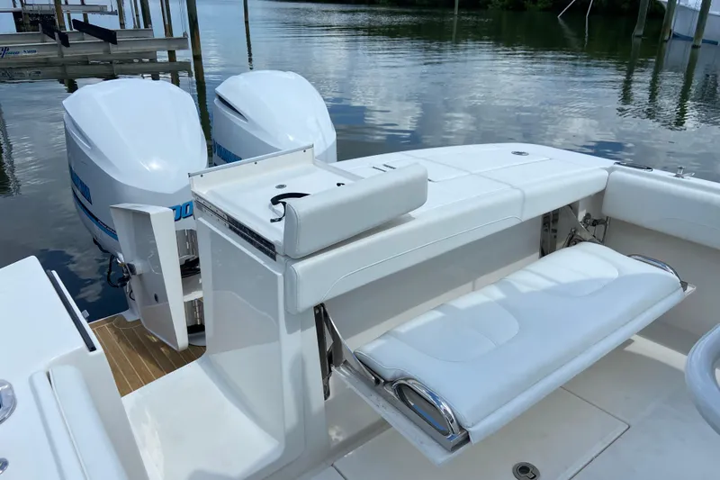 Slide: The Image of 2021 Regulator 28 boat with dual outboard engines and white seating, docked by calm waters. - 15