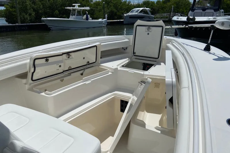 Slide: The Image of 2021 Regulator 28 boat with open storage compartments, docked near other boats. - 37