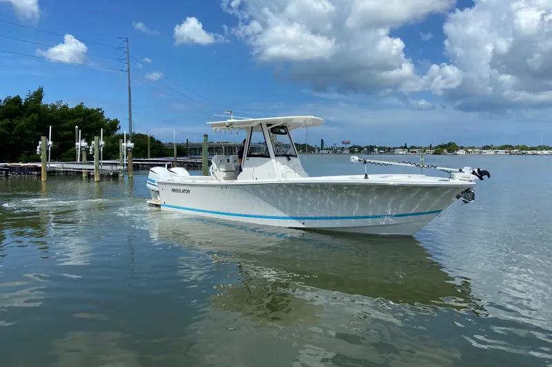 Slide: The Image of 2021 Regulator 28 boat on calm water under a partly cloudy sky. - 6