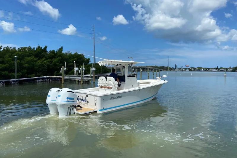 Slide: The Image of 2021 Regulator 28 boat cruising on calm waters under a clear blue sky. - 10