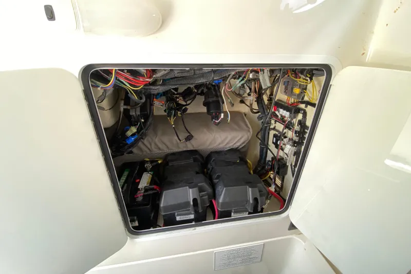 Slide: The Image of 2021 Regulator 28 boat electrical compartment with wiring and battery setup. - 48